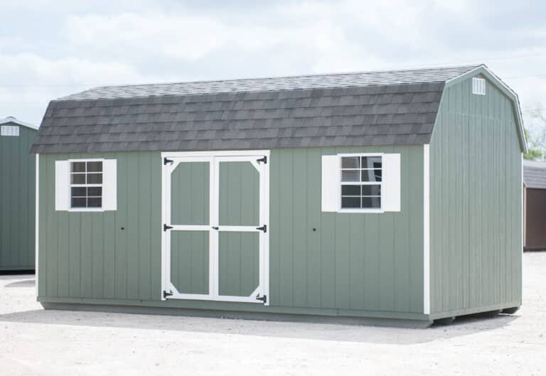 lofted barn dutchbarn dark grey, barn white trim weathered wood shingled roof shown with additional single wood door in texas