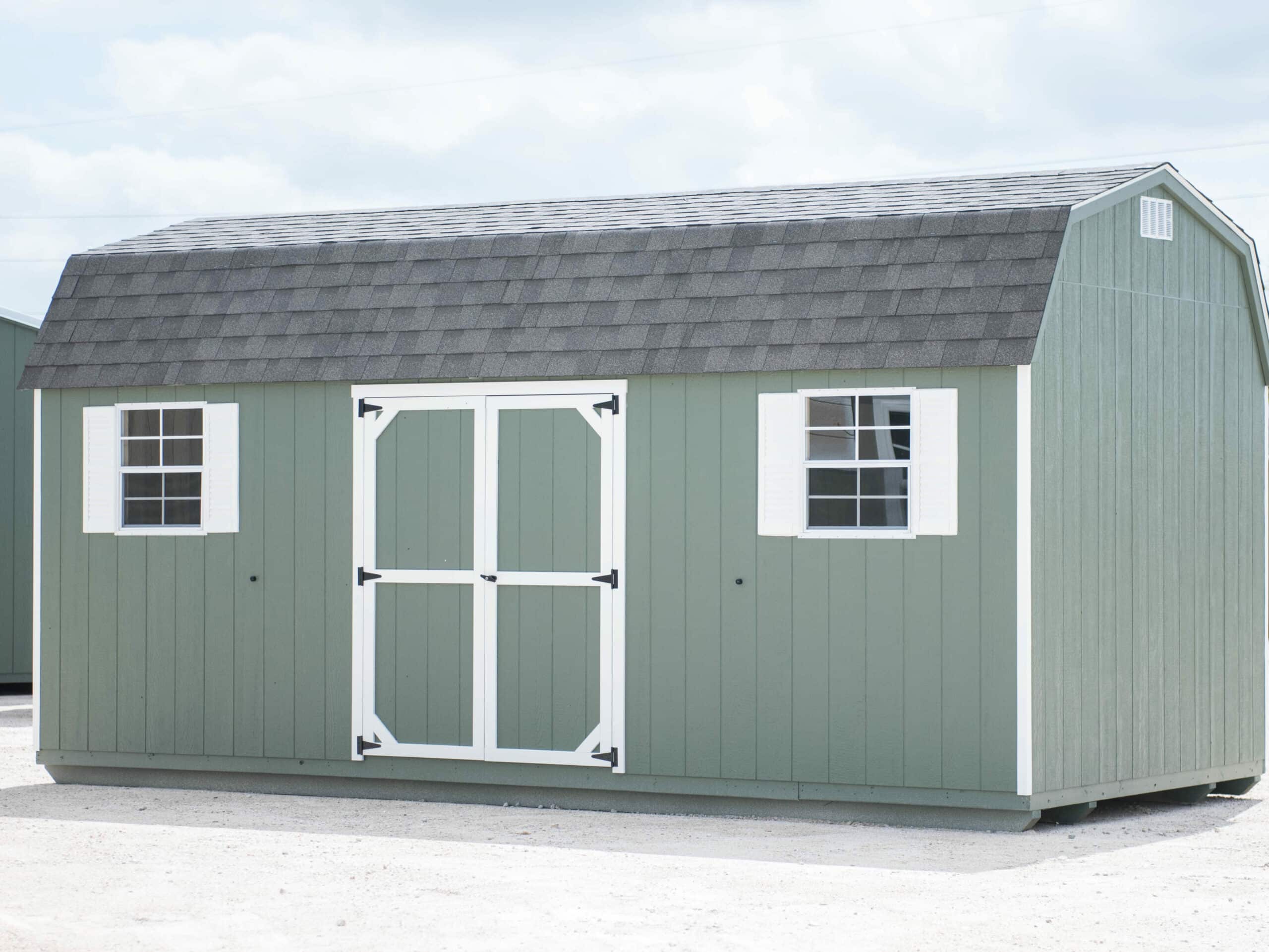 lofted barn dutchbarn dark grey, barn white trim weathered wood shingled roof shown with additional single wood door in texas